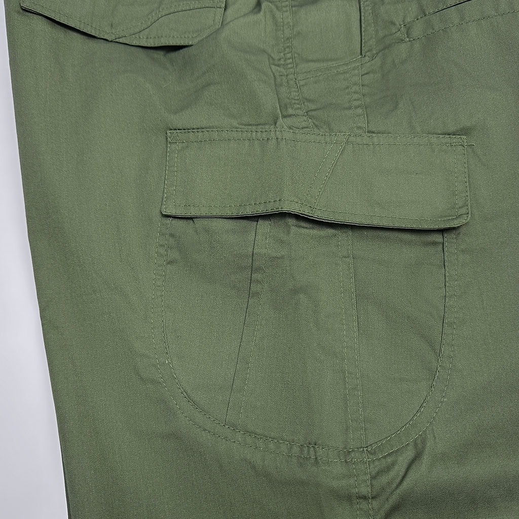 Close-up of the large, expandable side cargo pocket on the custom olive green tactical trousers.