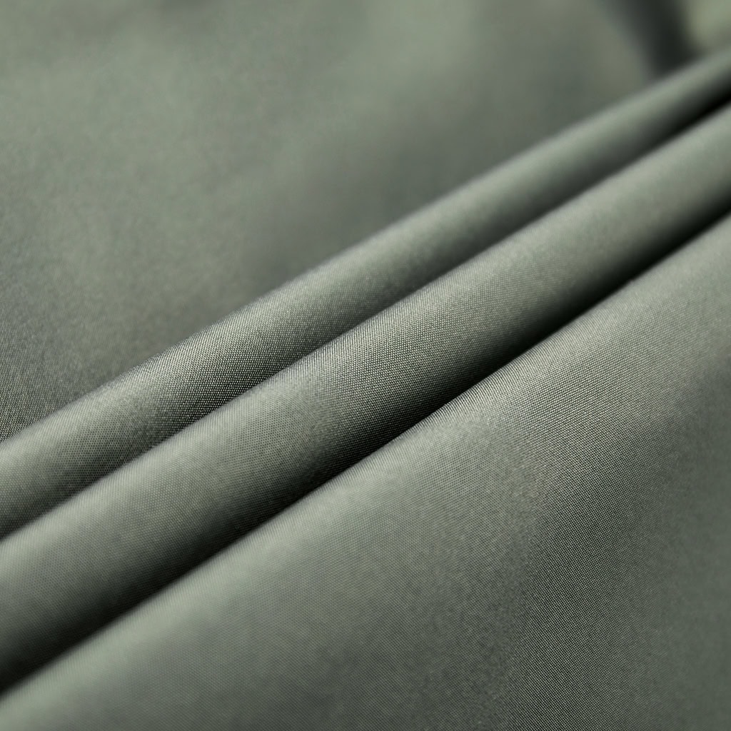 Close-up of the waterproof, PVC-coated 100% Nylon fabric in solid olive green.